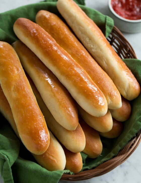 a basket filled with breadsticks sitting on top of a table