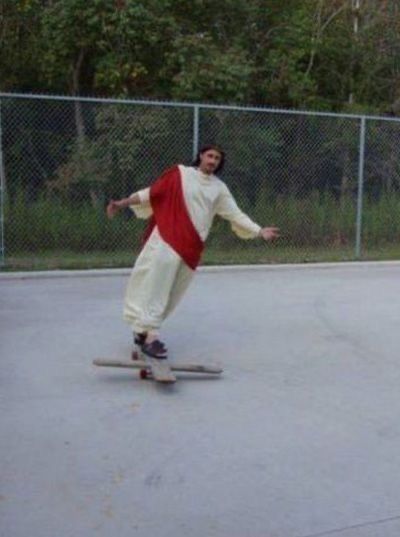 a man riding a skateboard on top of a cement ground next to a fence