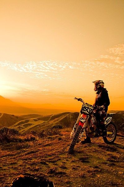 a man standing on top of a dirt bike