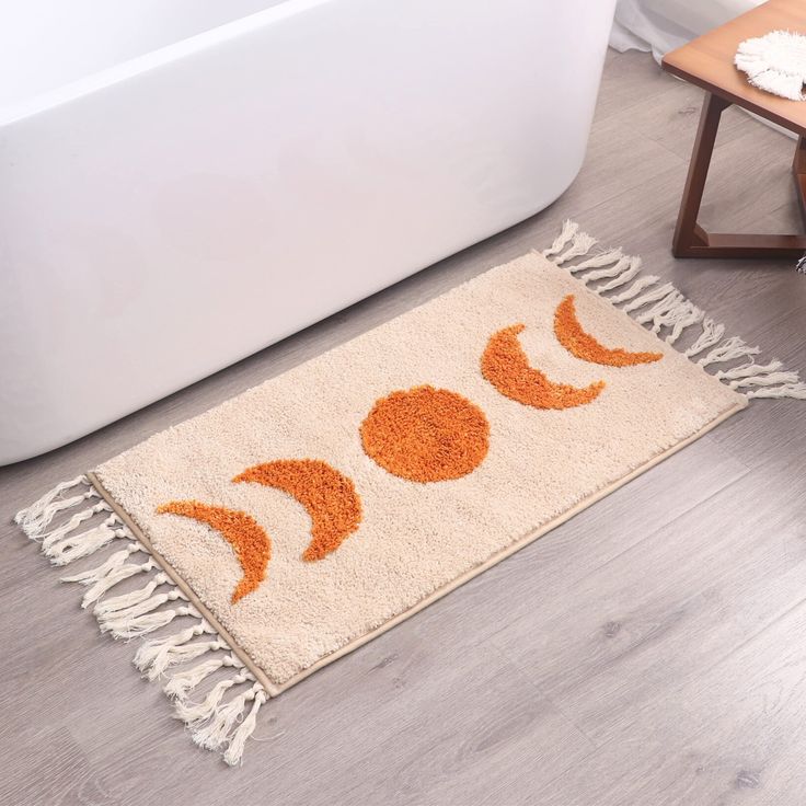 an orange and white rug on the floor next to a bath tub