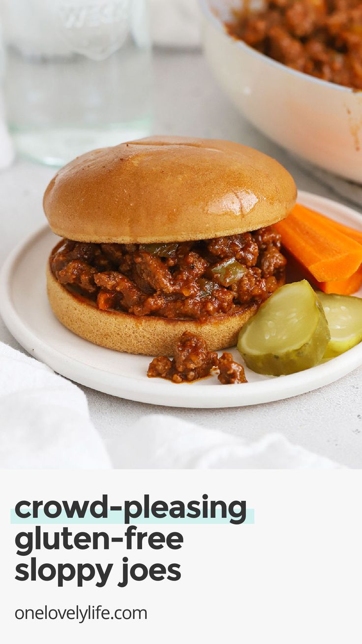 a sloppy joe sandwich on a plate with pickles and celery next to it