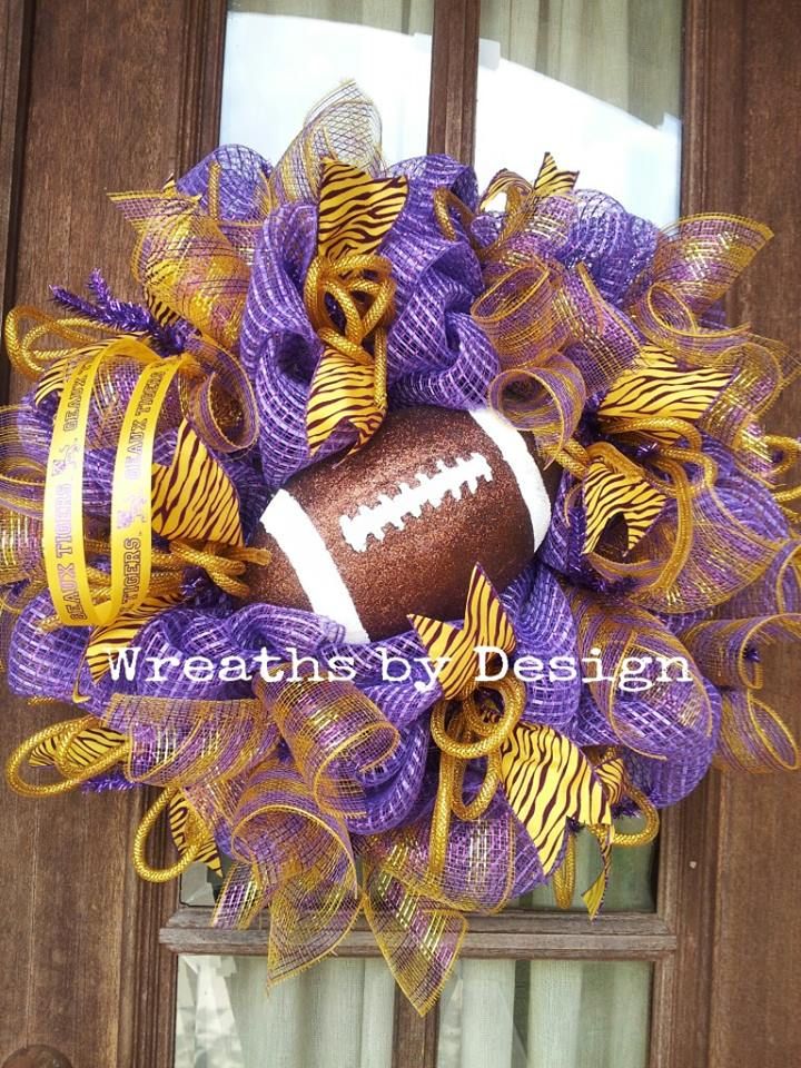 a purple and gold mesh wreath with a football on the front door, decorated with streamers