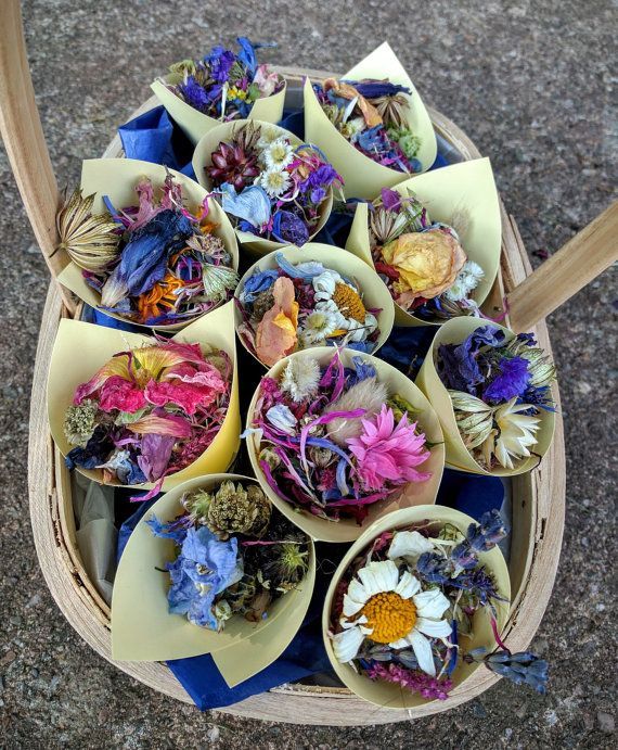 a basket filled with lots of different types of flowers on top of a cement ground