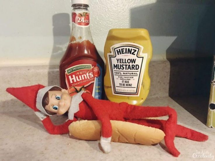 an elf laying on the ground next to some condiments and a bottle of mustard