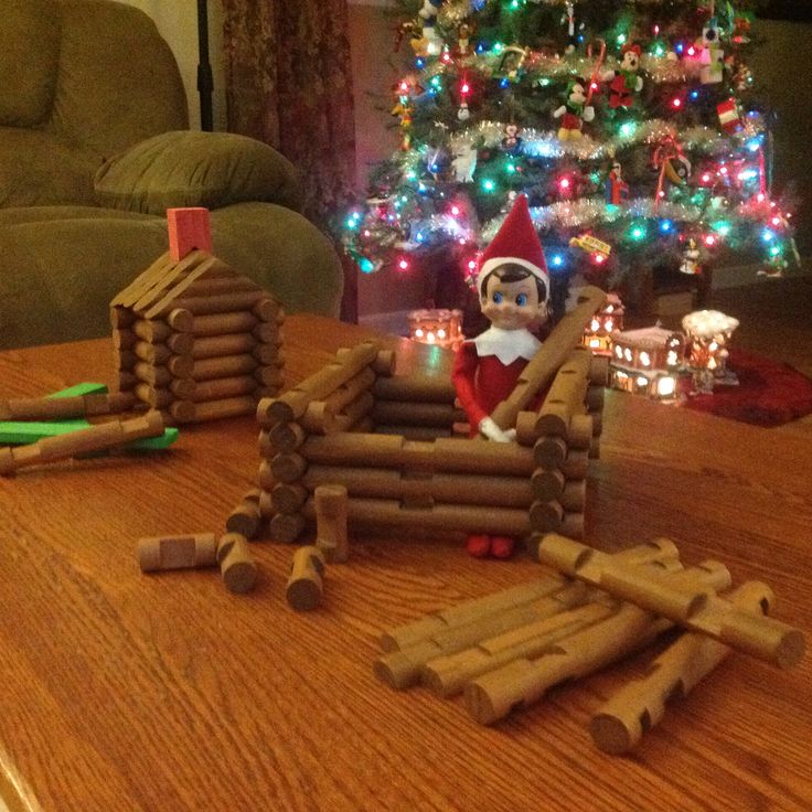 an elf sitting in front of a pile of logs on top of a wooden table