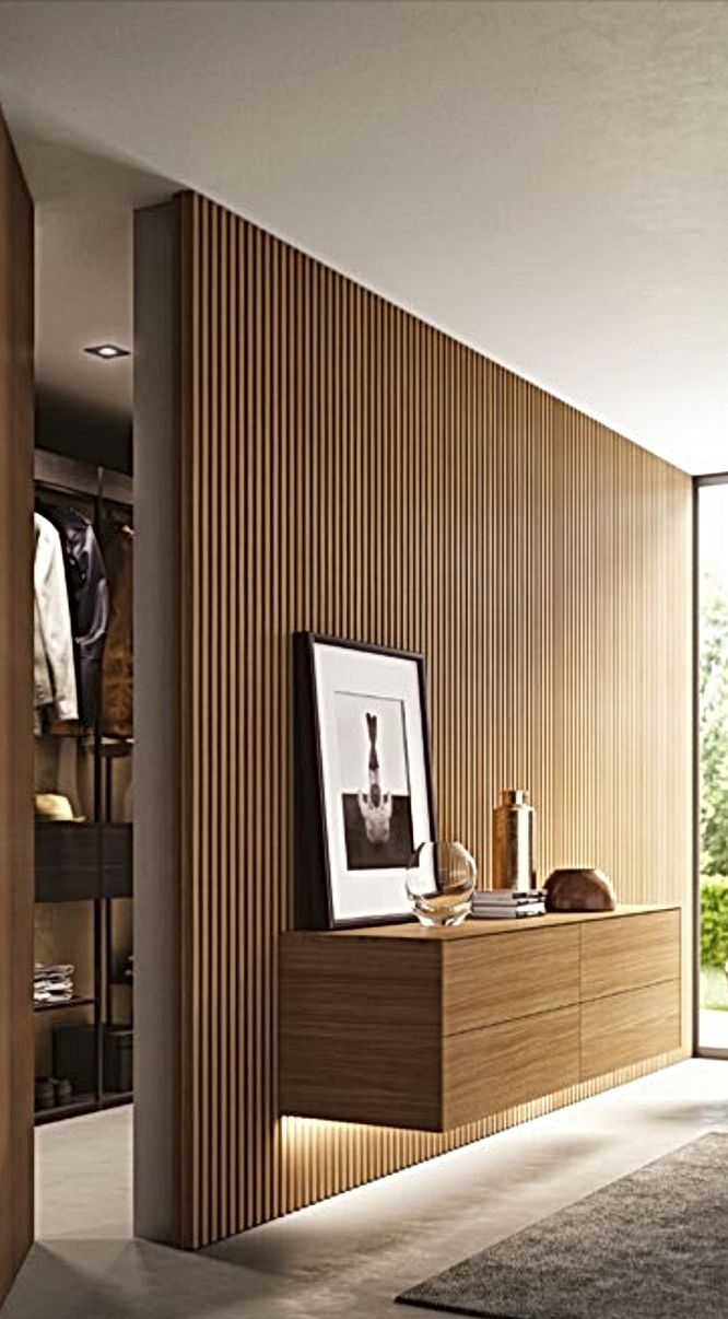 an open closet with clothes hanging on the wall and a framed photograph in front of it