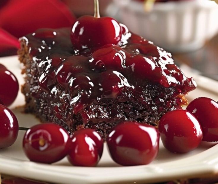 a piece of chocolate cake with cherries on it