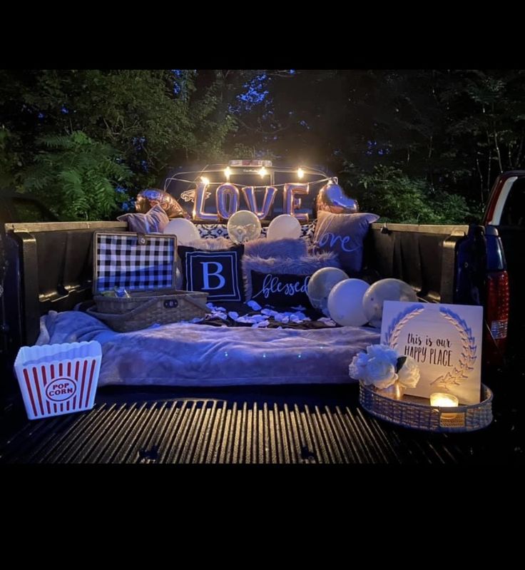 a bed with pillows and lights on it in the back of a pick up truck