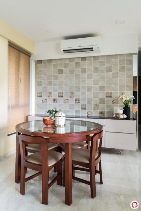 a kitchen table with chairs around it in front of a wall mounted air conditioner