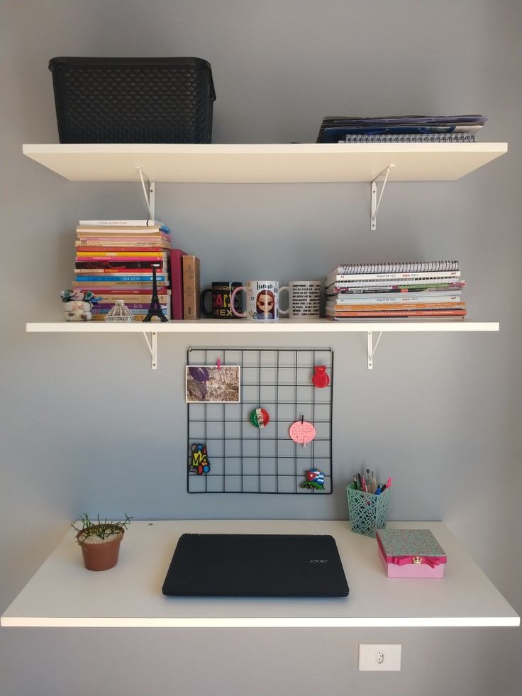 a white desk topped with two shelves filled with books and other office supplies on top of it