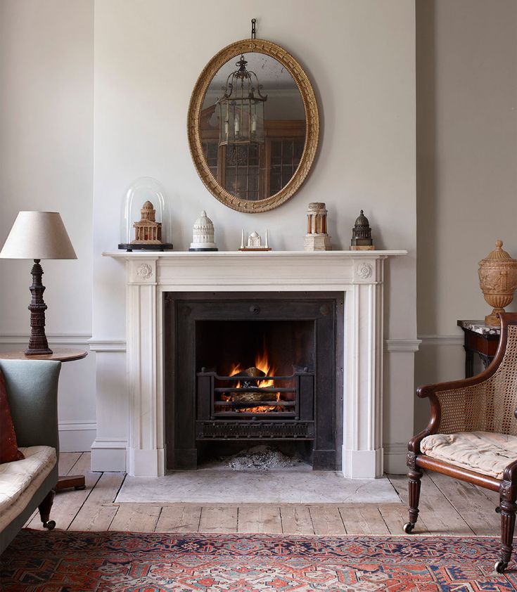 a living room with a fire place and mirror on the wall next to couches