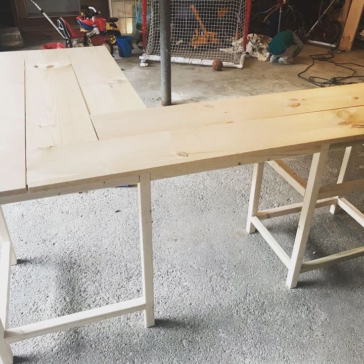 a wooden bench sitting in a garage next to a metal pole and some other tools