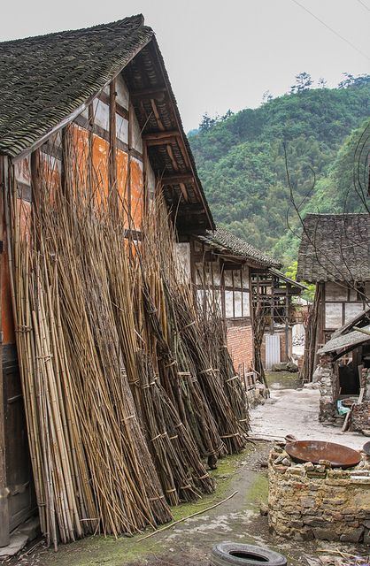 an old village with wooden buildings and lots of bamboo sticks sticking out of the roof