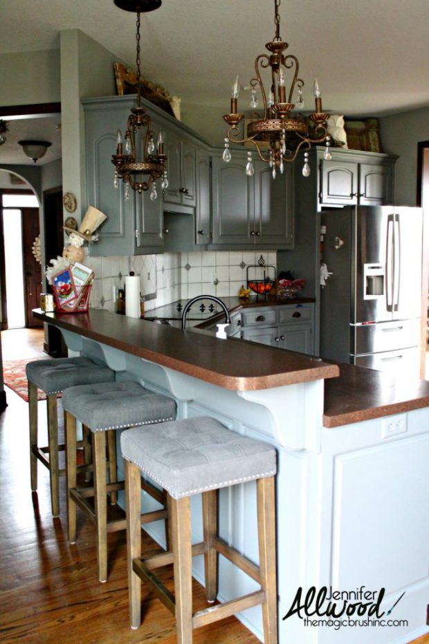 a kitchen island with stools in front of it and a chandelier hanging from the ceiling