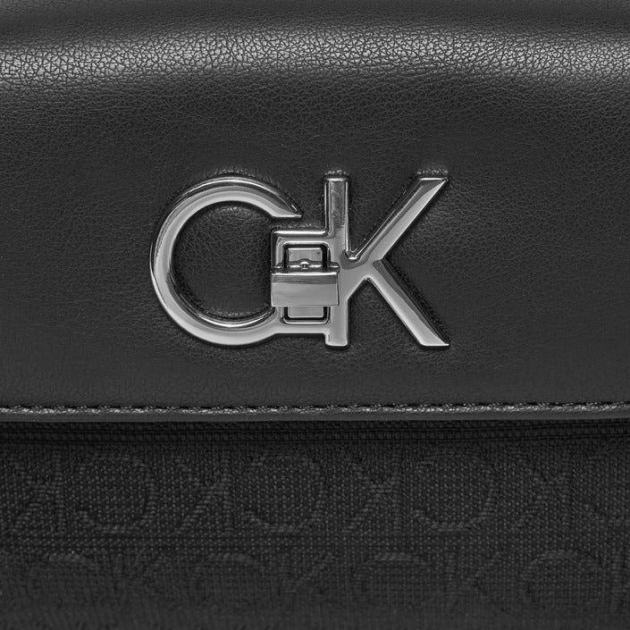 Brand: Calvin Klein Gender: Women Type: Bags Season: Spring/Summer PRODUCT DETAIL • Color: black • Pattern: plain • Fastening: with clip • Size (cm): 12x18x4 • Details: -handbag -with shoulder strap COMPOSITION AND MATERIAL • Composition: -78% polyester -22% polyurethane Modern Satchel With Logo Hardware For Daily Use, Black Satchel With Logo Hardware For Daily Use, Black Business Shoulder Bag With Branded Hardware, Black Rectangular Satchel With Logo, Black Satchel Bag With Logo Hardware, Rectangular Shoulder Bag With Logo For Travel, Rectangular Shoulder Bag With Logo Hardware For Travel, Black Top Handle Satchel With Logo, Modern Calvin Klein Shoulder Bag For Business