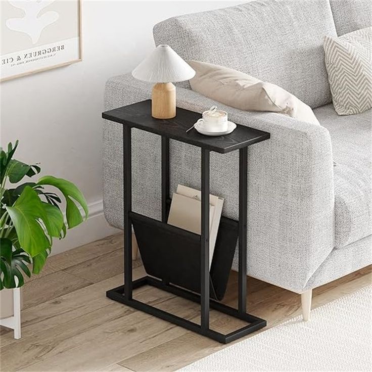 a living room with a couch, coffee table and potted plant on the floor