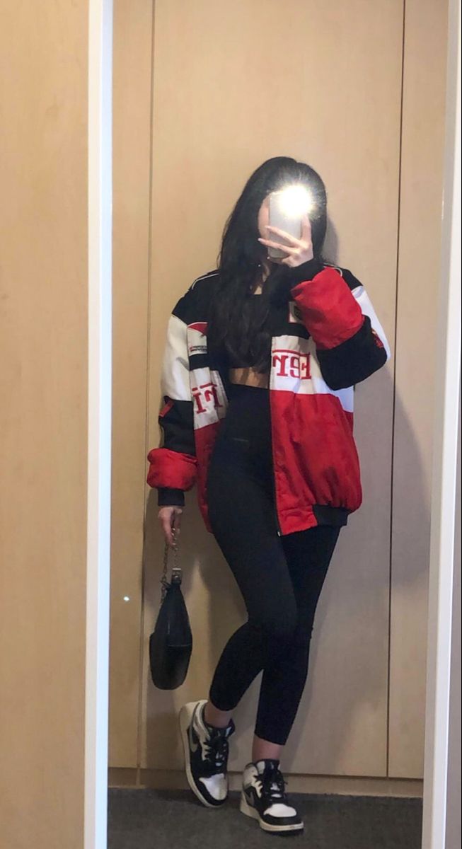 girl with dark long hair wearing black leggings, black top, ferrari racer jacket, black shoulder bag and jordan’s in a mirror pic Outfits With Racing Jacket, F1 Racer Jacket, Ferrari F1 Outfit, F1 Race Day Outfits, Racing Style Outfits, F1 Inspired Outfits, Ferrari Jacket Aesthetic, Race Track Outfit Women, Race Outfit Women