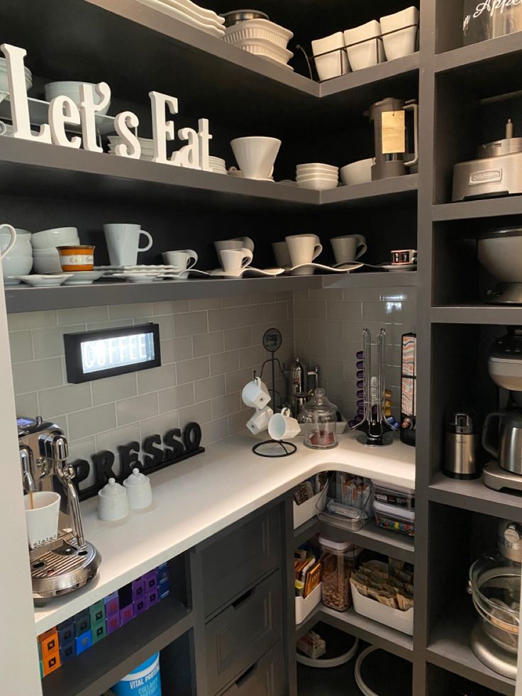 a kitchen with lots of dishes and cups on the shelves