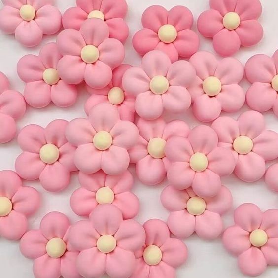 pink and white flowers are arranged together on a white tablecloth with yellow dots in the center