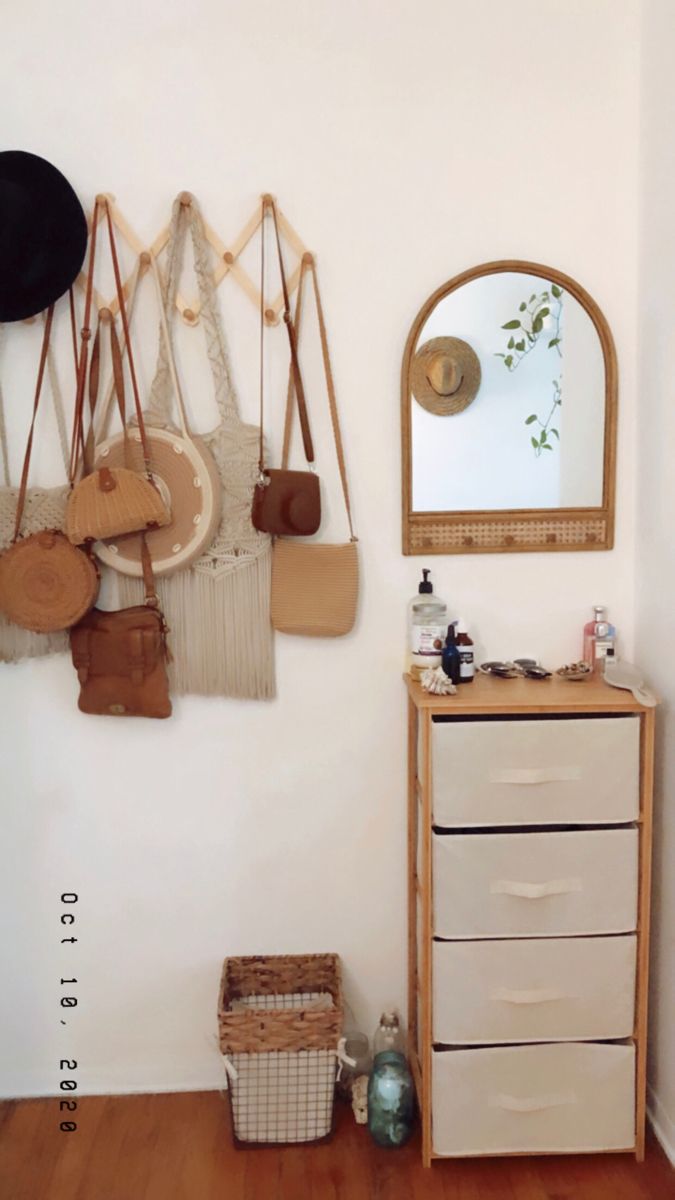 a white dresser sitting next to a wall with hanging objects on it's sides