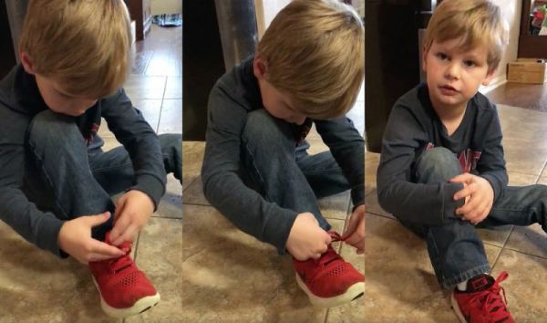 two young boys sitting on the floor tying their red tennis shoes with one shoelace