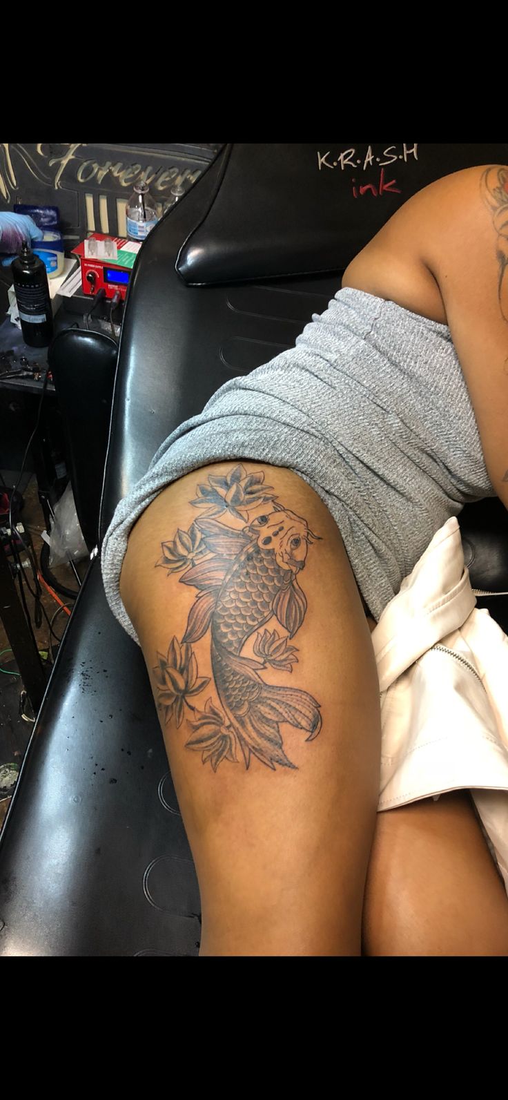 a woman with a fish tattoo on her thigh