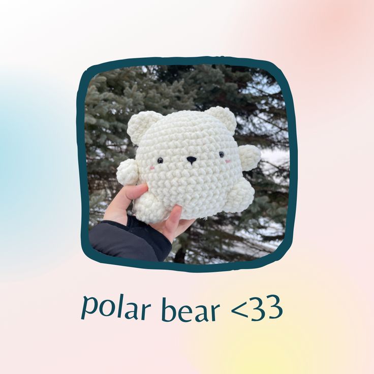 a hand holding a crocheted polar bear in front of a pine tree with the caption polar bear