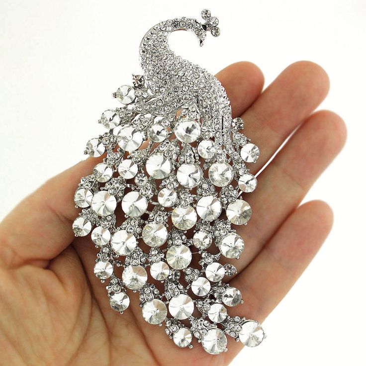 "Gorgeous large rhinestone peacock brooch jewelry embellishment, which can be used for your DIY project - peacock theme wedding bridal brooch bouquet, ring pillow, invitations, cake decorations, event decor, crafts, scrap booking and much more! Perfect for peacock theme wedding! Size: 4 1/4\"H x 2 1/4\"W Stones: Clear crystal Metal color: Silver plated This crystal broach can be ordered with pin in the back to add to wedding gown or dress sash, to wire into brooch bouquet, or any number of other craft projects; or without the pin as a flat back embellishment for your sew-on, glue-on DIY project. More SILVER brooches - https://www.etsy.com/shop/Crystalitzy?section_id=16136267&ref=shopsection_leftnav_1 Please note that this crystal rhinestone embellishment has flat backing, it is suitable on Peacock Theme Wedding, Bouquet Ring, Peacock Brooch, Bridal Brooch, Bridal Brooch Bouquet, Brooch Dress, Peacock Theme, Dress Sash, Brooch Bouquet