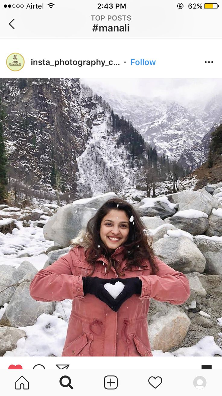 a woman is taking a selfie in the snow with her heart on her chest