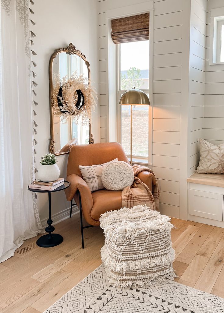 a living room filled with furniture and a mirror on the wall next to a window