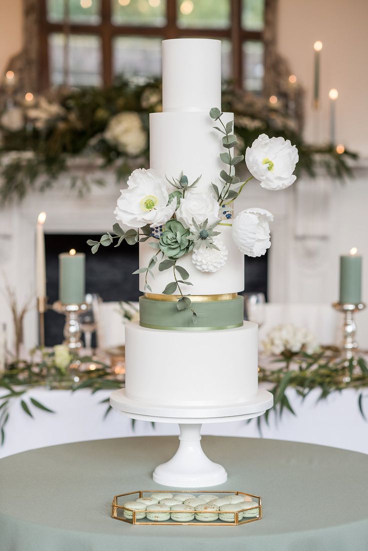 a wedding cake with white flowers and greenery