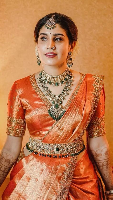 a woman in an orange and gold sari