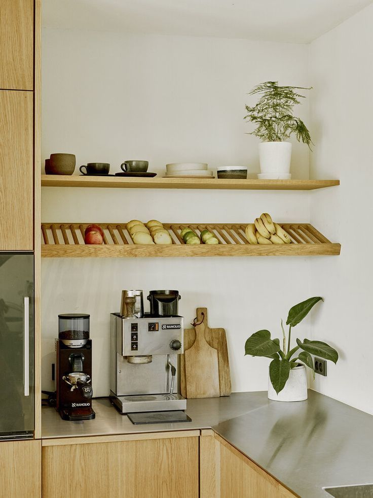 some food is sitting on the shelves above the coffee maker and other kitchen items in front of it