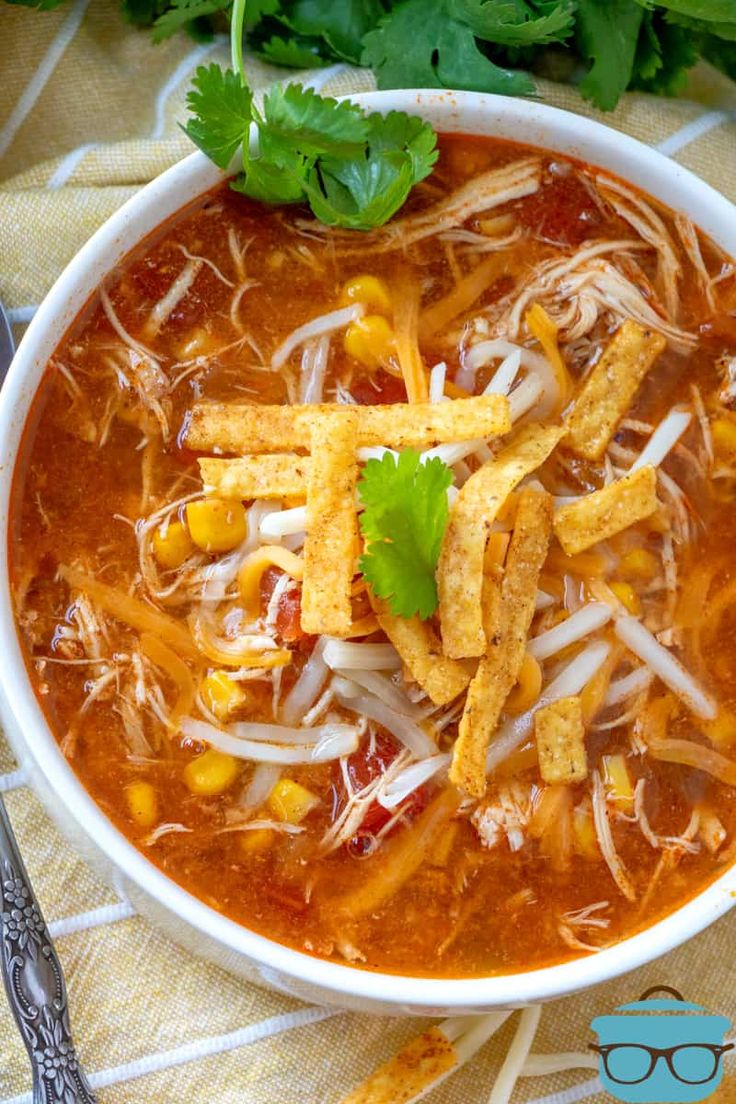 a white bowl filled with taco soup and tortilla chips on top of it