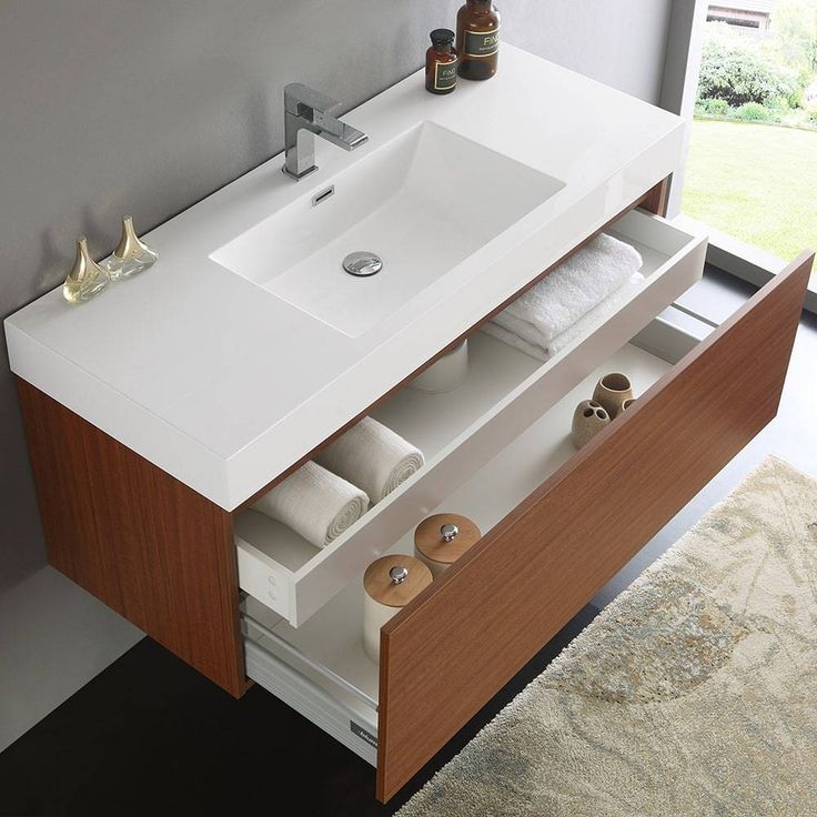 a bathroom vanity with two drawers and a sink in front of a window that looks out onto the yard