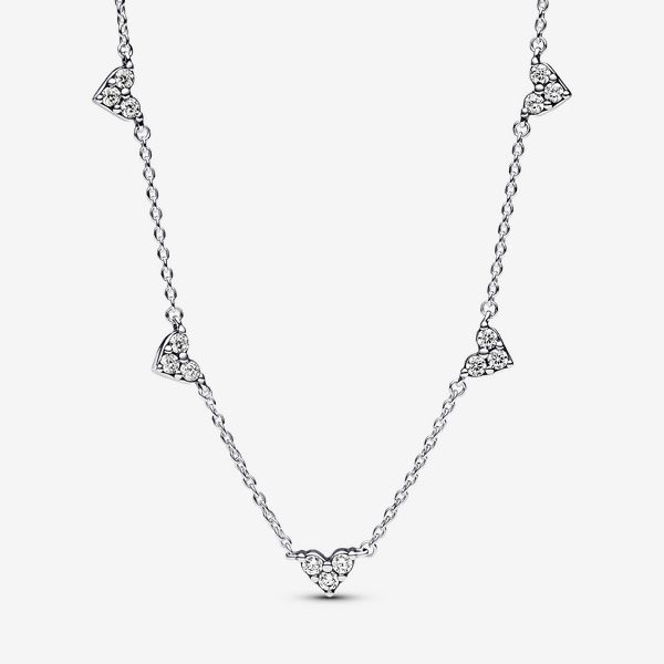 Embody elegance with the Triple Stone Heart Station Chain Necklace from our Pandora Timeless collection. Crafted from sterling silver, it features five mini three-stone heart motifs affixed to the chain, creating a timeless look with a twist of emotion. The adjustable 45 cm chain, with a subtle Pandora logo, ensures a perfect fit. With a heartfelt motif and a delicate nod to the beauty of sparkle, this necklace is an ideal gift for special occasions or a stylish addition to your own collection. - Pandora Triple Stone Heart Station Chain Necklace - Sterling silver / Cubic Zirconia / Clear - Sz. 17.7 in Cute Silver Necklaces, Pandora Heart Necklace, Pandora Logo, Pandora Heart, Pandora Hearts, Stone Heart, Three Stone, Heart Necklace, Silver Necklaces