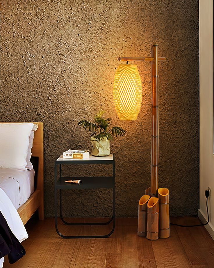 a lamp that is on top of a table next to a night stand and bed