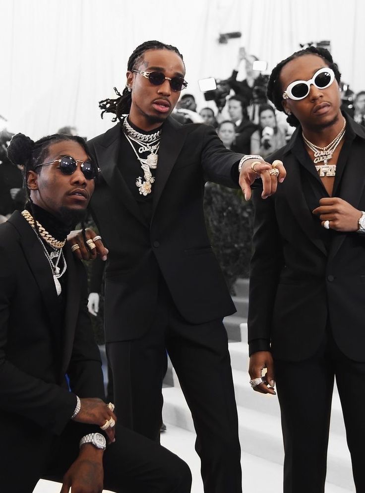 three men in suits and sunglasses posing for the camera