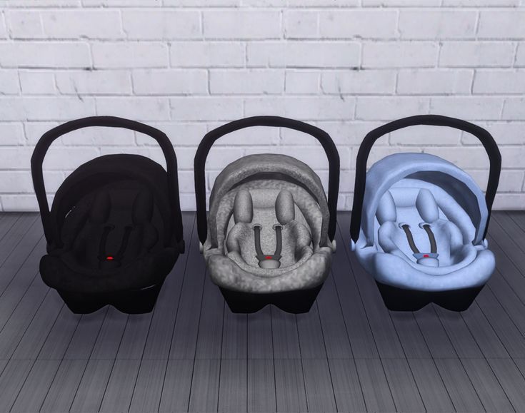 three different colored baby seats in front of a brick wall