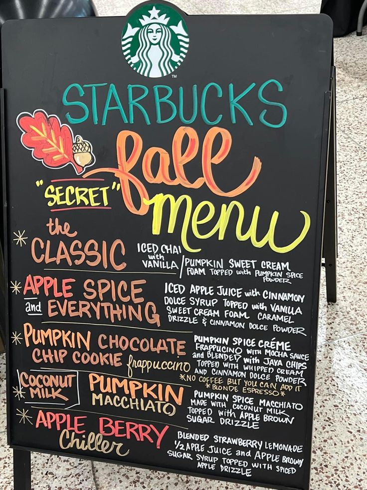 the starbucks menu is written on a black board