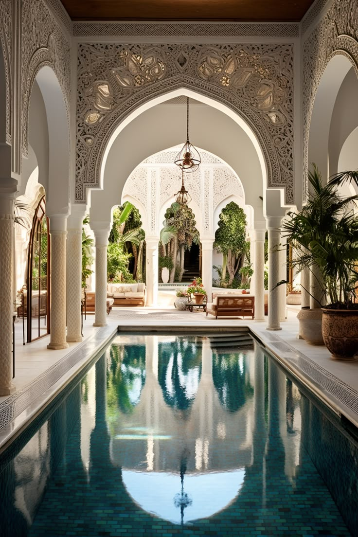 an indoor swimming pool in the middle of a building with arches and columns around it