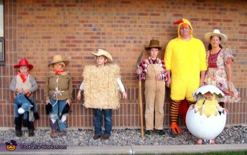 a group of people standing next to each other near a brick wall with fake eggs