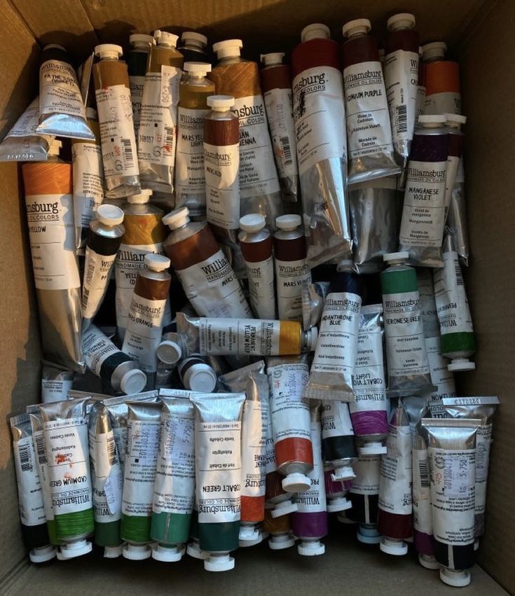 a cardboard box filled with lots of different types of paint