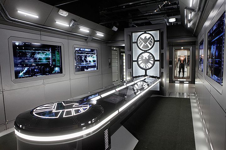 the interior of a futuristic looking building with two televisions on either side of it