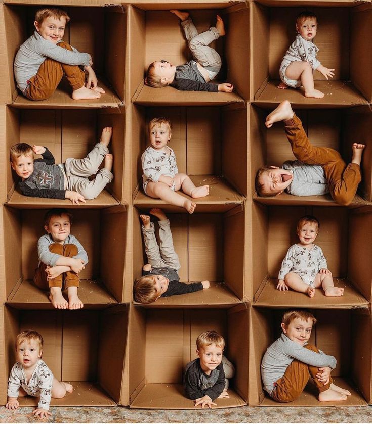 a group of children laying on top of cardboard boxes