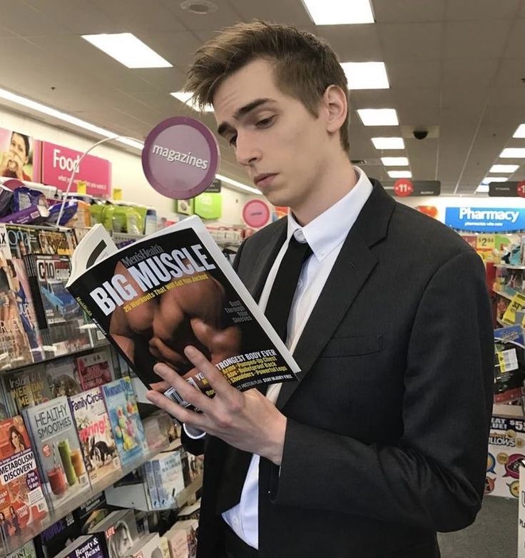 a man in a suit reading a magazine