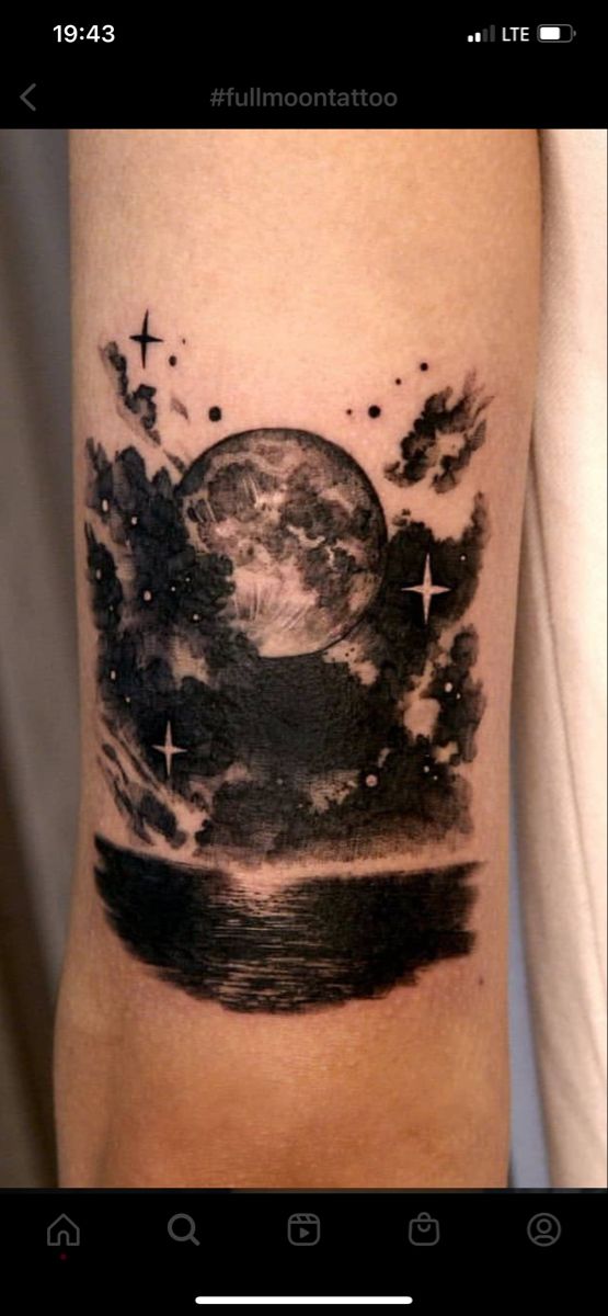 a black and white photo of the earth on someone's arm with stars around it