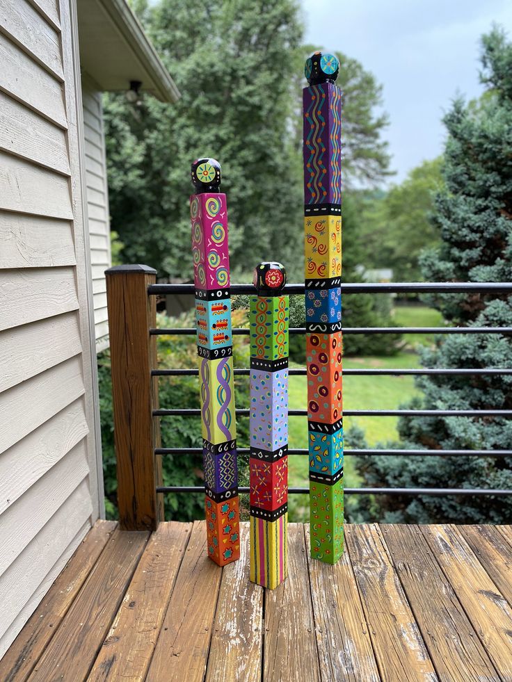 several colorful items are stacked on top of each other in front of a house and trees