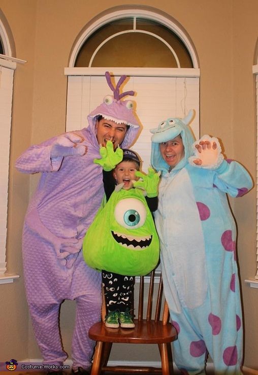 three adults and two children in costumes posing for the camera with one child on a rocking chair