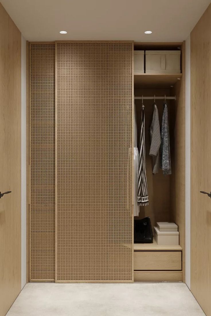 an open closet with some clothes hanging on the wall and two doors that are closed